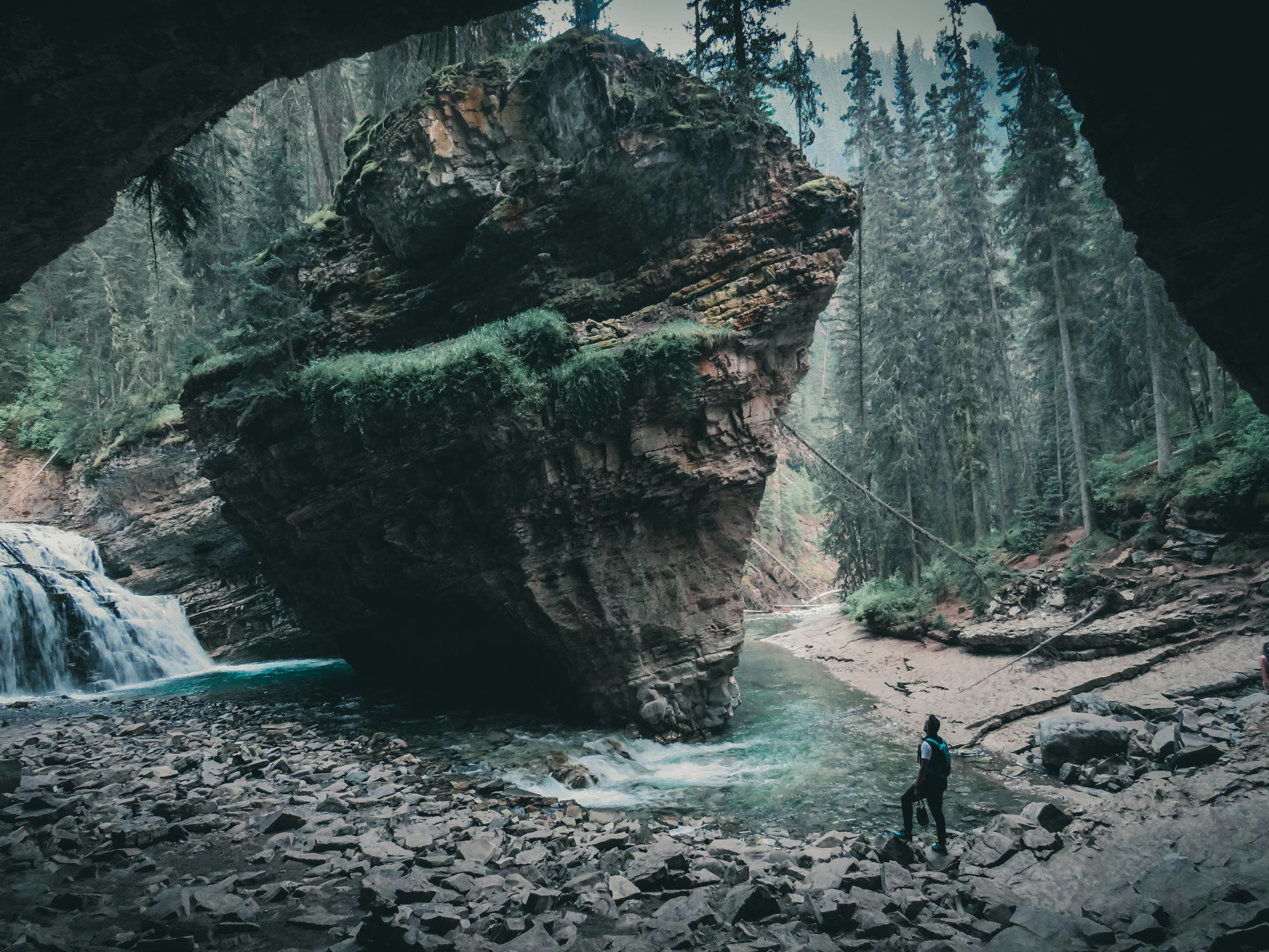 person in black jacket standing on rocky shore during daytime